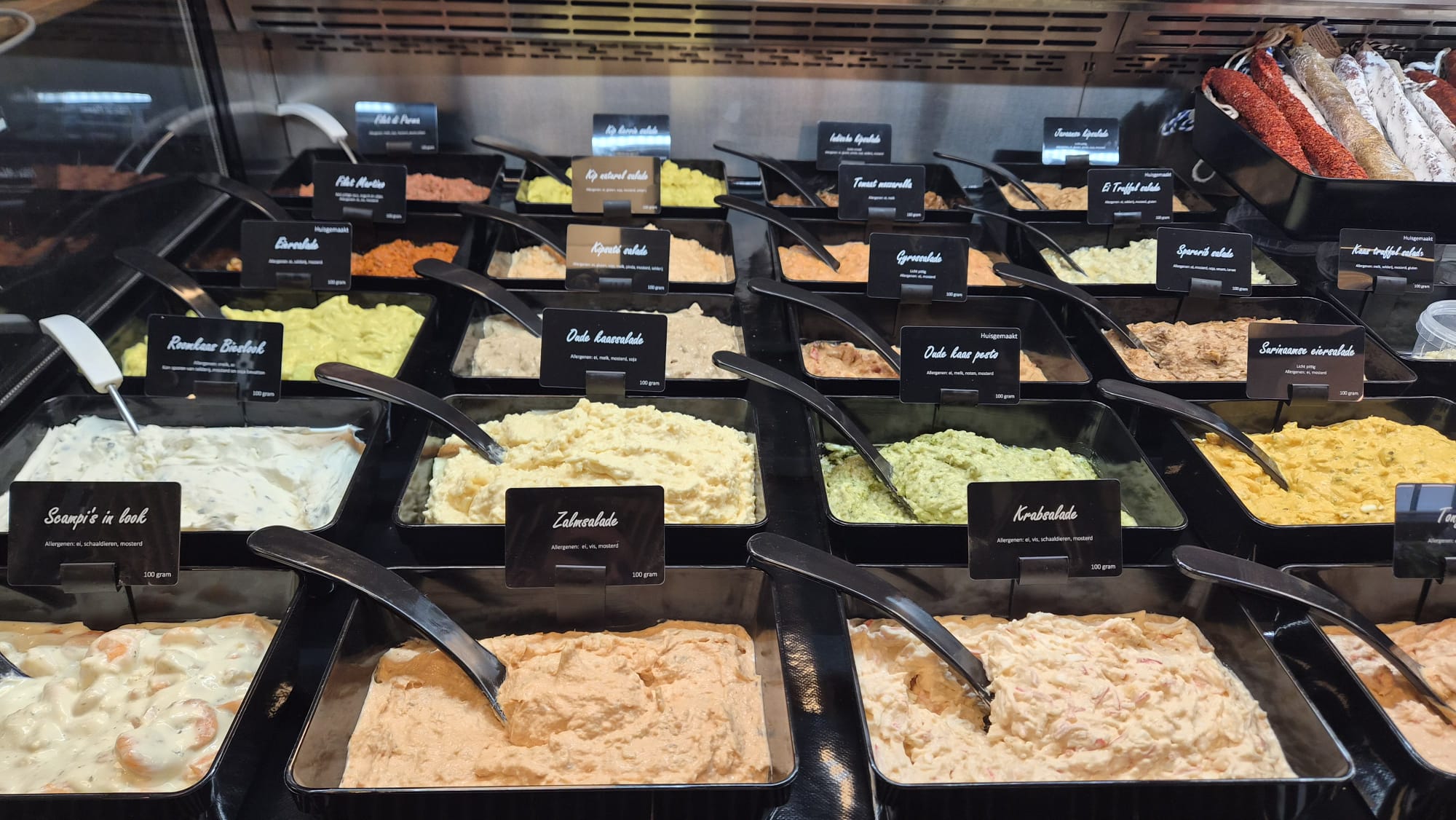 Verse salades met productkaartjes in de toonbank van De Bossche Bourgondiër